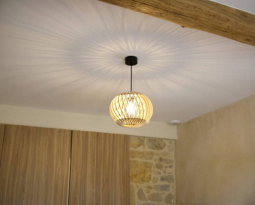 Suspension en bois Alban projetant ses ombres dansantes sur un plafond blanc