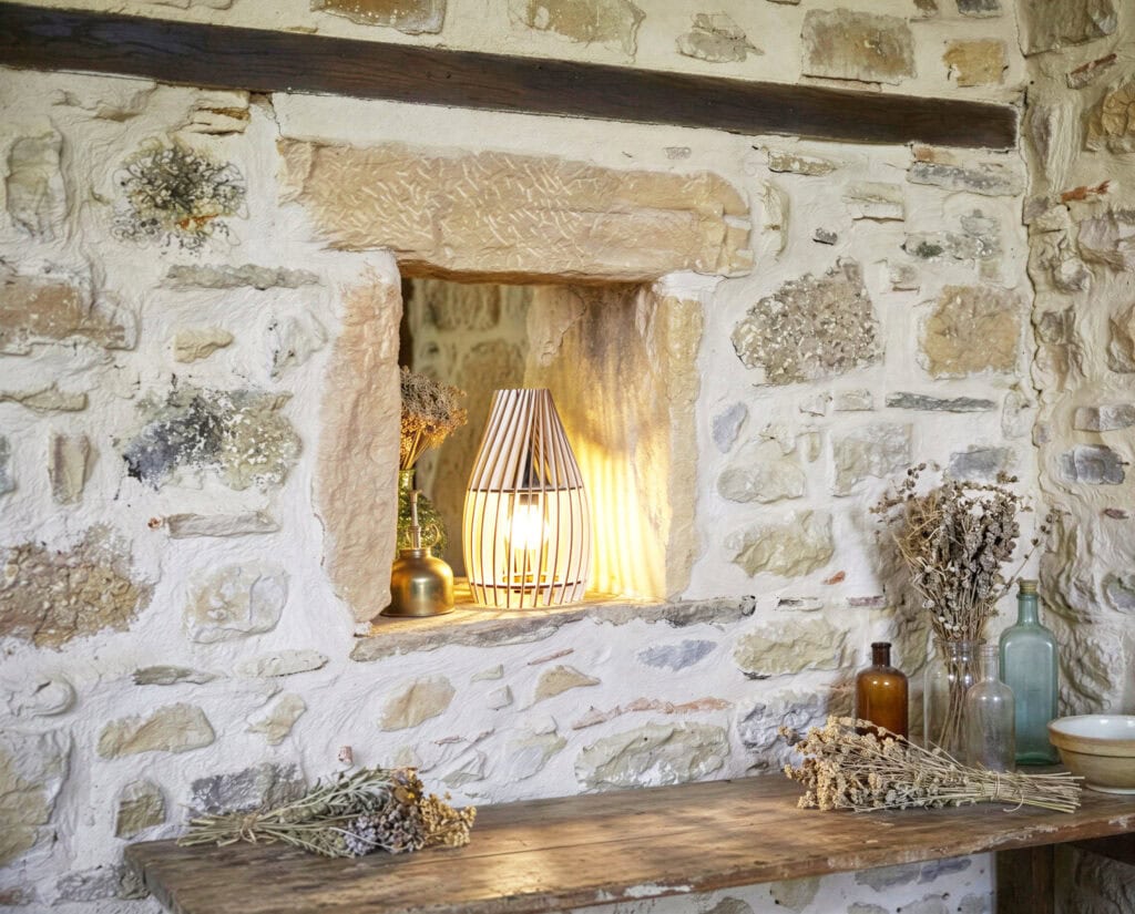 Une lampe à poser design avec un mur en pierre et une déco naturelle